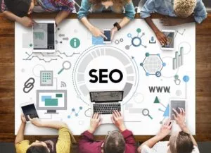 workers around a table showing SEO