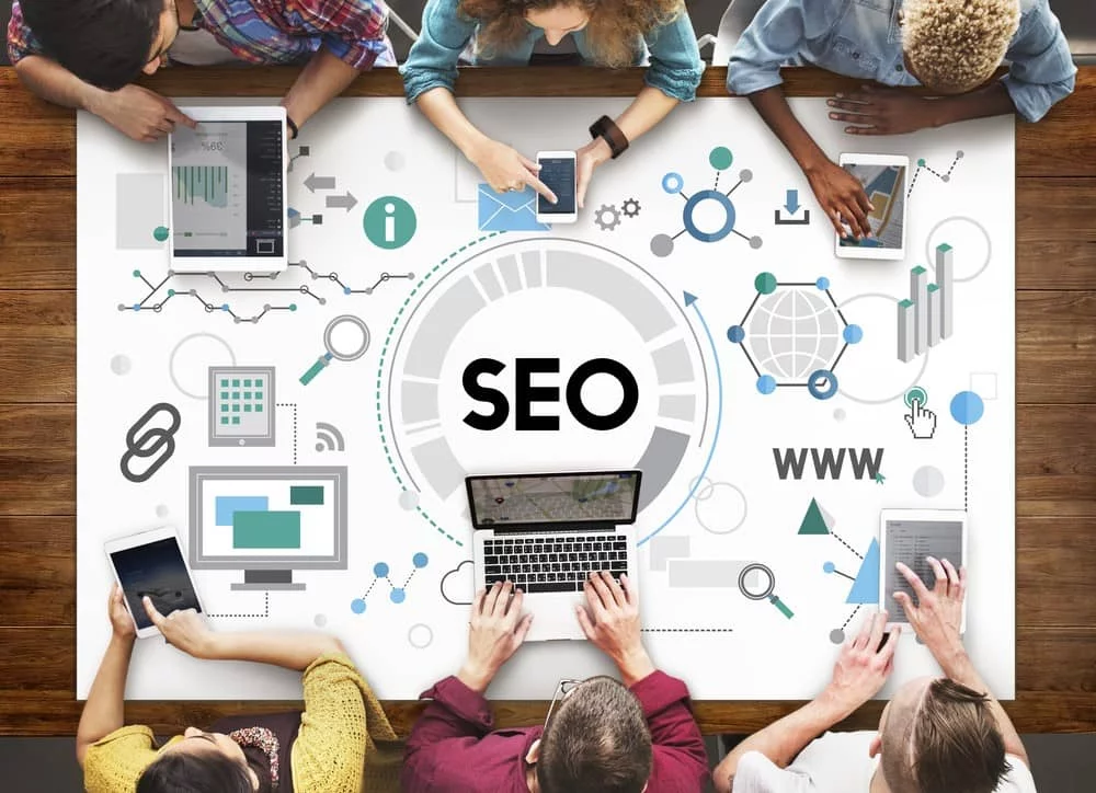 workers around a table showing SEO