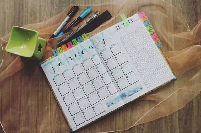 a calendar sitting on a table near markers