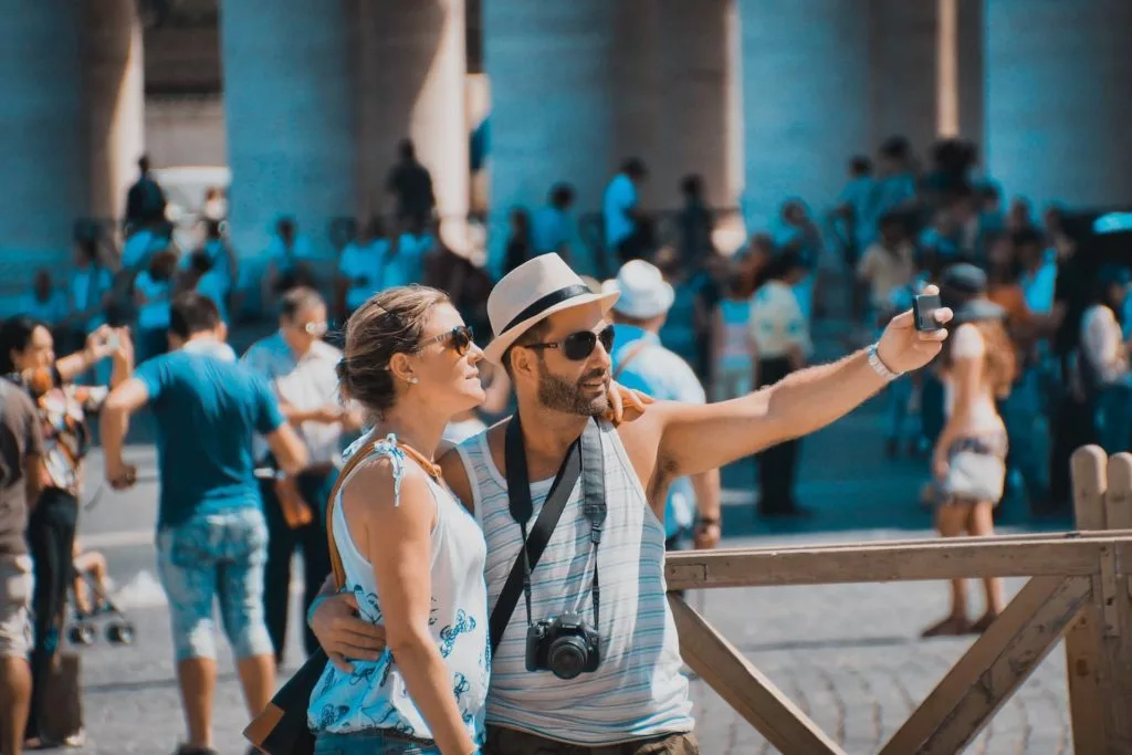 A pair of travelers taking a selfie together at a popular tourist attraction